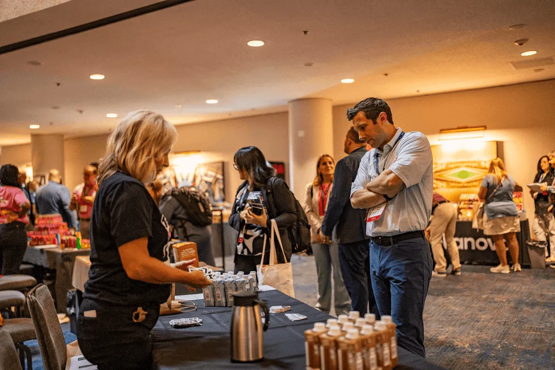 Participants of All Access event by Vistar North viewing industry participant booth