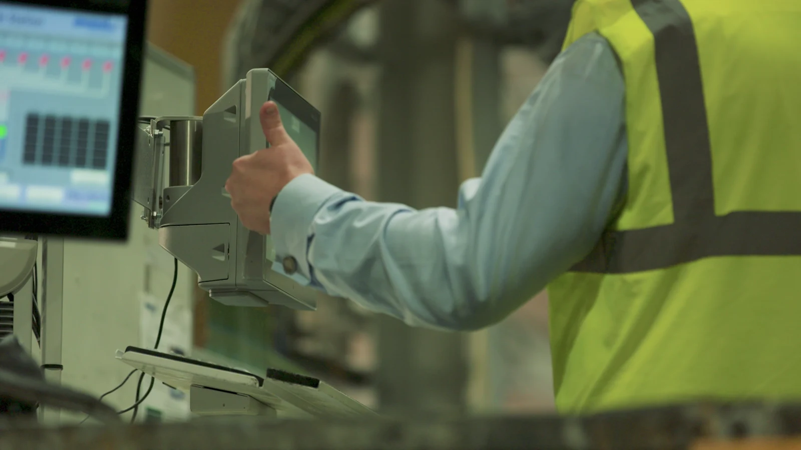 Operator using a shop-floor touchscreen showing live production data