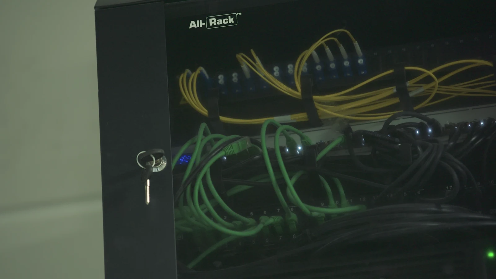 Network cabinet with structured patch cabling and switches on a factory wall