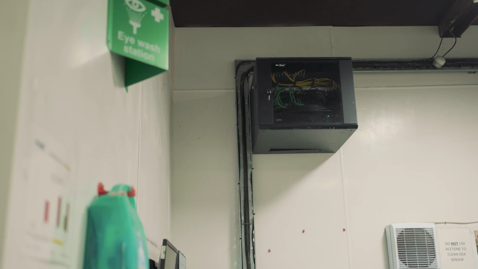 Wall-mounted network cabinet installed on a production floor