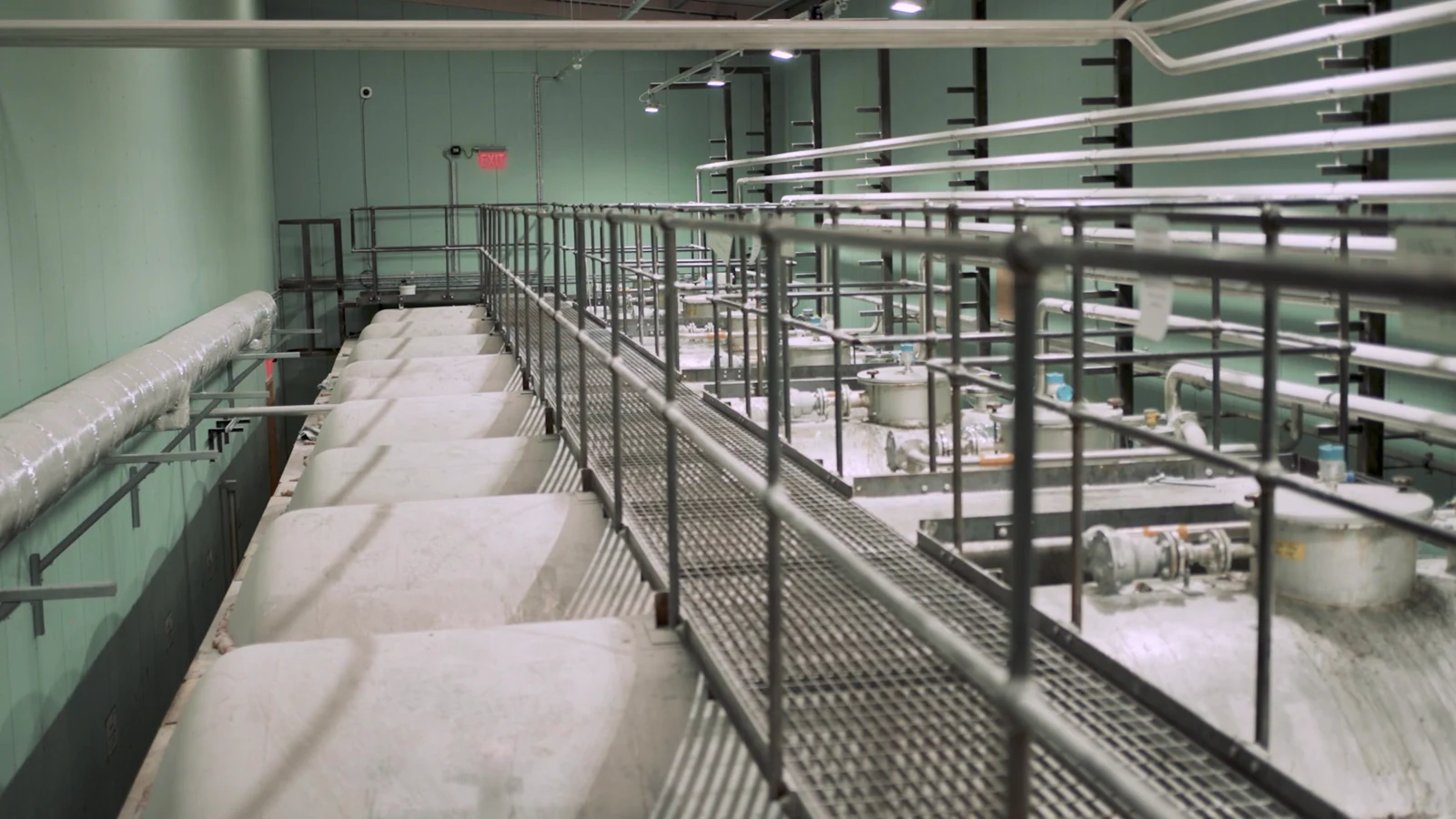 Elevated walkway over mixing vessels in a manufacturing plant