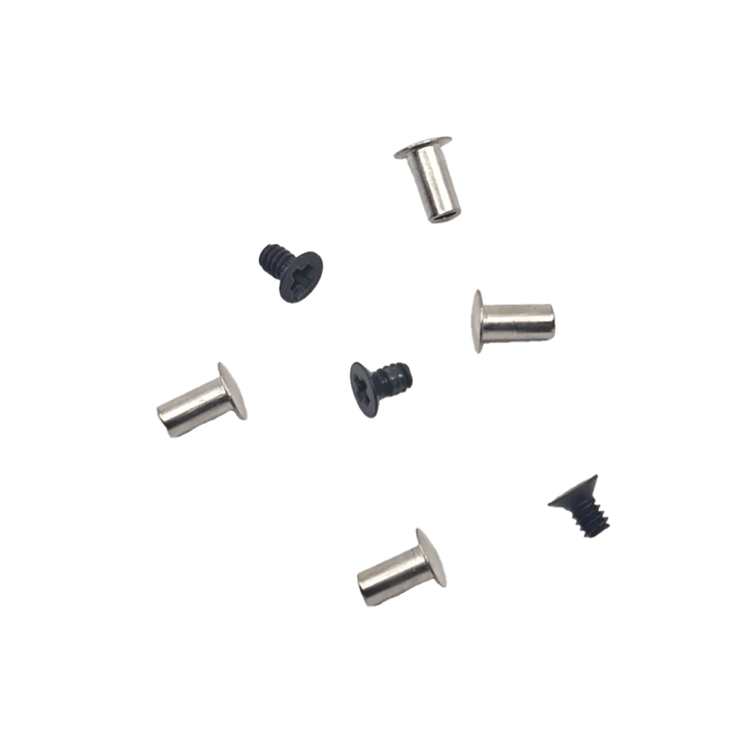 Five metal barrel nuts and four black Phillips screws scattered on a light surface.