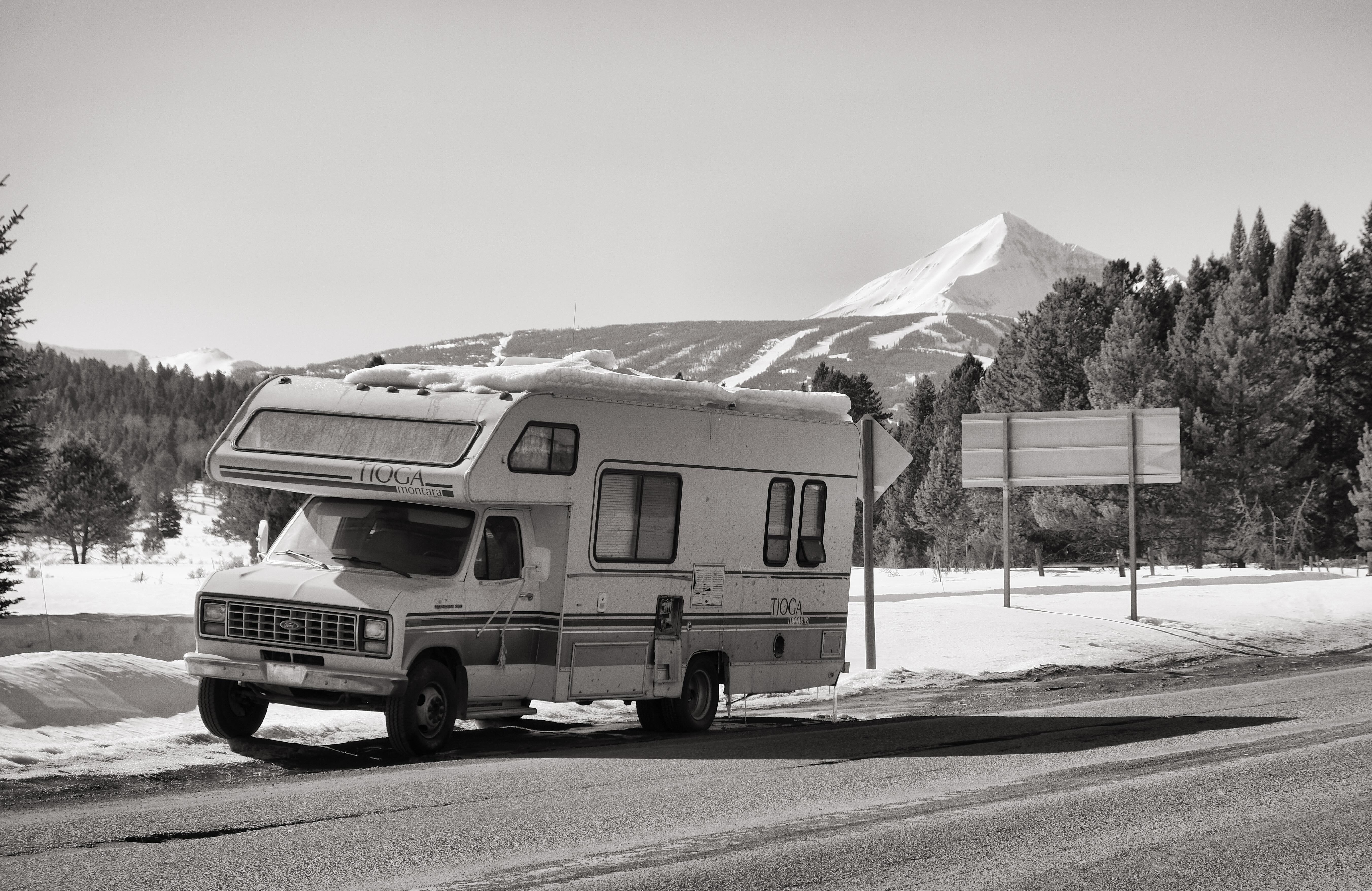 A run down RV in front of a mountain