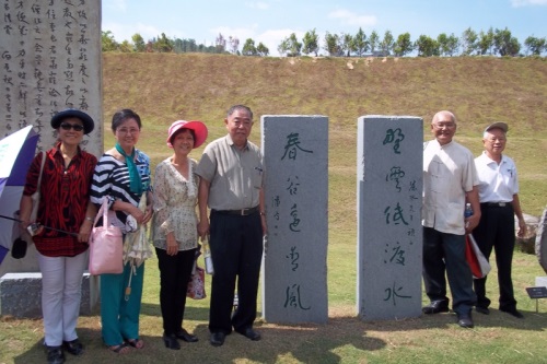 南大校友在潘受的书法碑前合影，左起：杨金枝、潘斯里魏顺莲、胡玉颜、缪进新会长。右一：李福生、陈健诚。