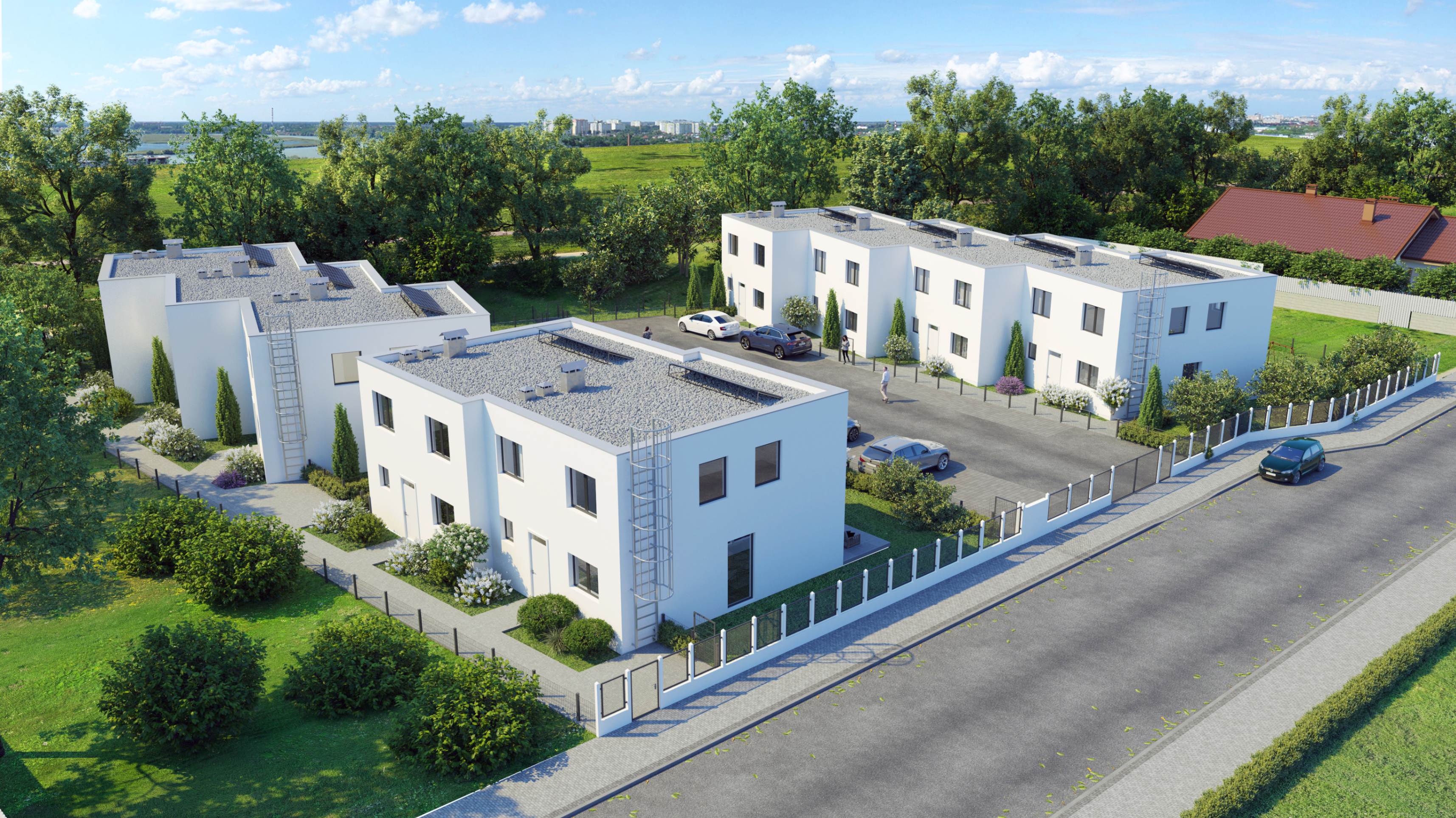 Moderne weiße Wohngebäude mit Flachdächern, umgeben von grünen Bäumen und gepflegten Sträuchern, mit parkenden Autos und einer Straße im Vordergrund.