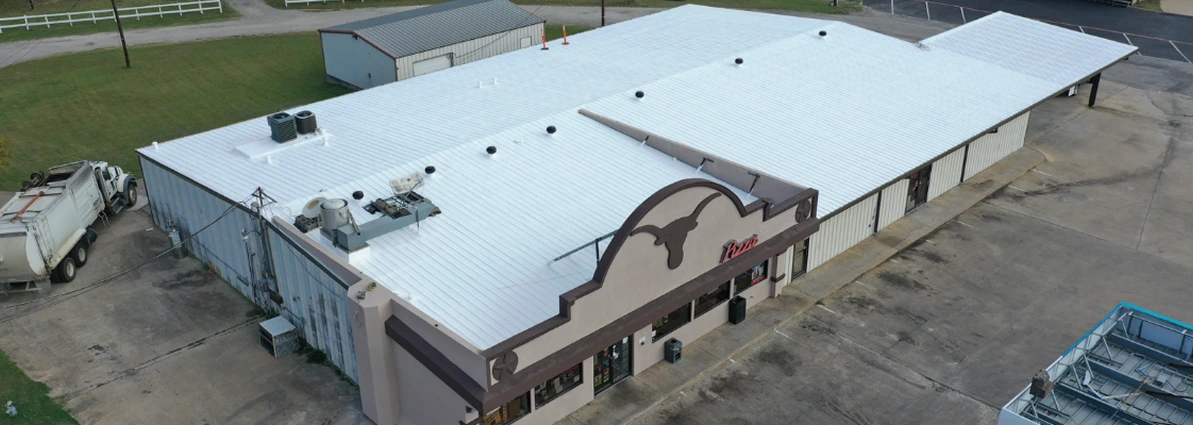 Aerial view of a large building complex with a playground, parking lots, and surrounding grass areas.