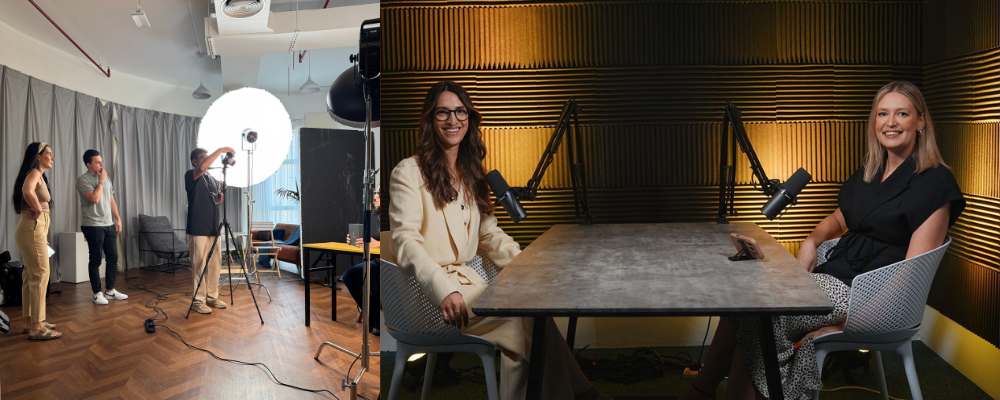 Two female founders sitting at a table with microphones in a soundproofed podcast studio, and a photographer capturing images with a production team for an event in a separate room.