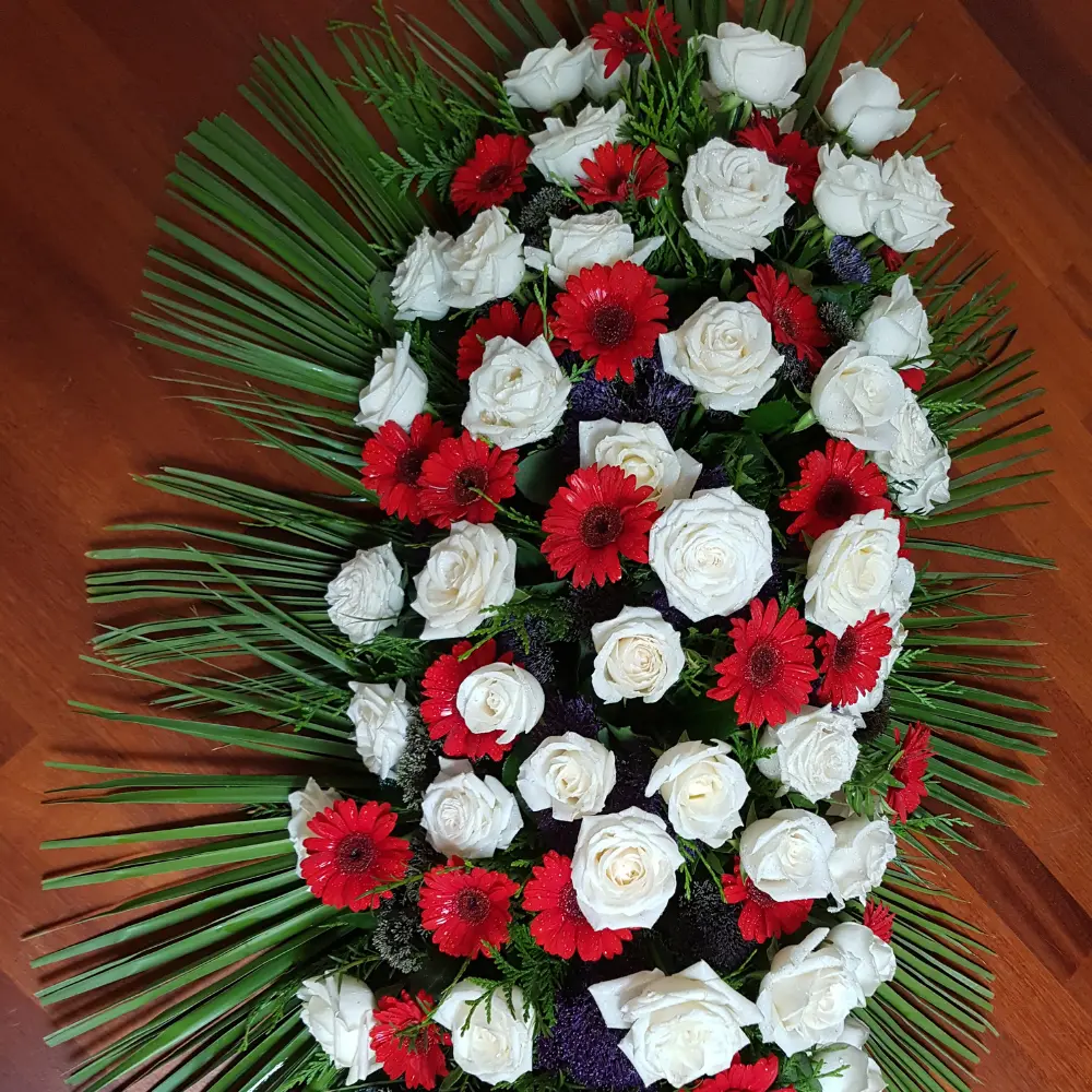 Couronne de deuil rouge et blanche avec gerberas et roses pour un hommage floral à Genève avec livraison de fleurs dans toute la Suisse