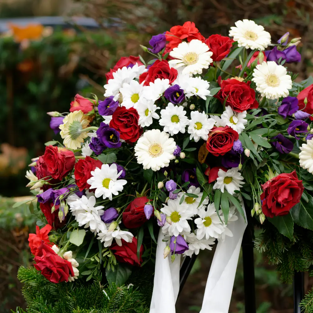 Couronne de deuil multicolore avec gerberas et roses et ruban blanc pour rendre hommage à Genève avec livraison de fleurs dans toute la Suisse