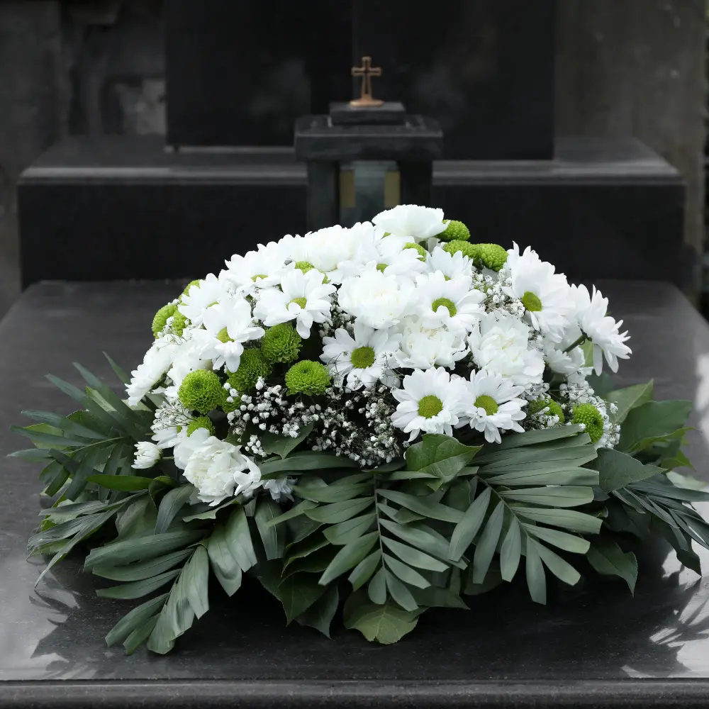 Coussin de deuil en fleurs blanches avec feuillage pour rendre hommage à Genève avec livraison de fleurs dans toute la Suisse