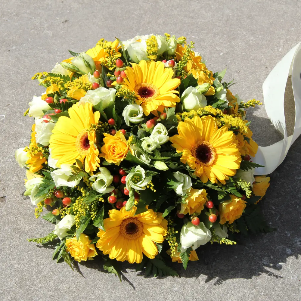 Coussin de deuil jaune avec gerberas et petites fleurs blanches pour un hommage lumineux à Genève avec livraison de fleurs dans toute la Suisse