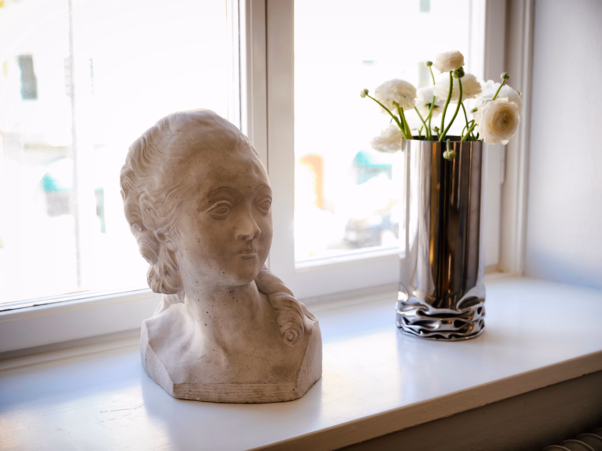 Plaster bust and white flowers on a window sill in the EndoHealth clinic