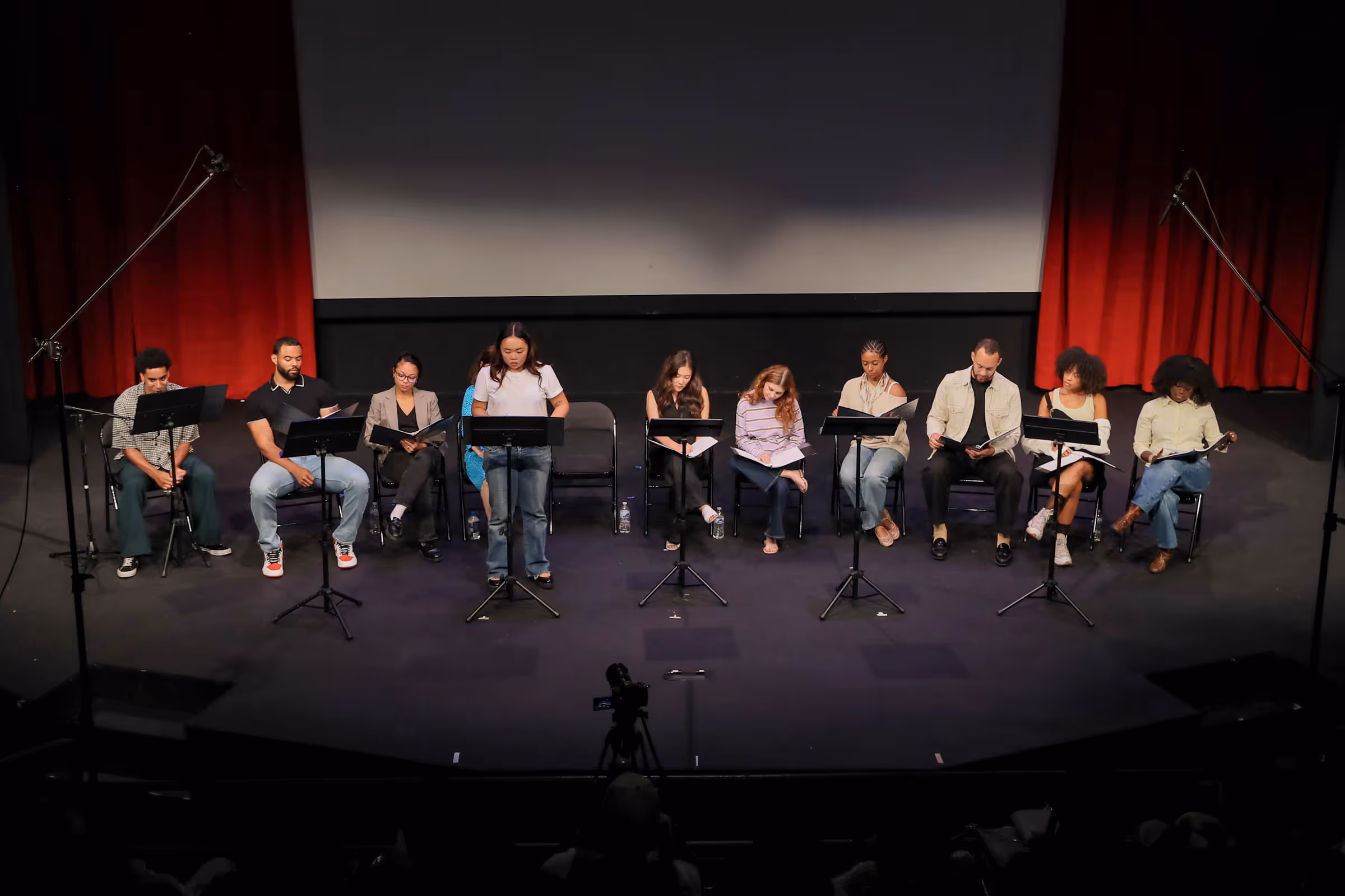 a group of people sitting on chairs with microphones