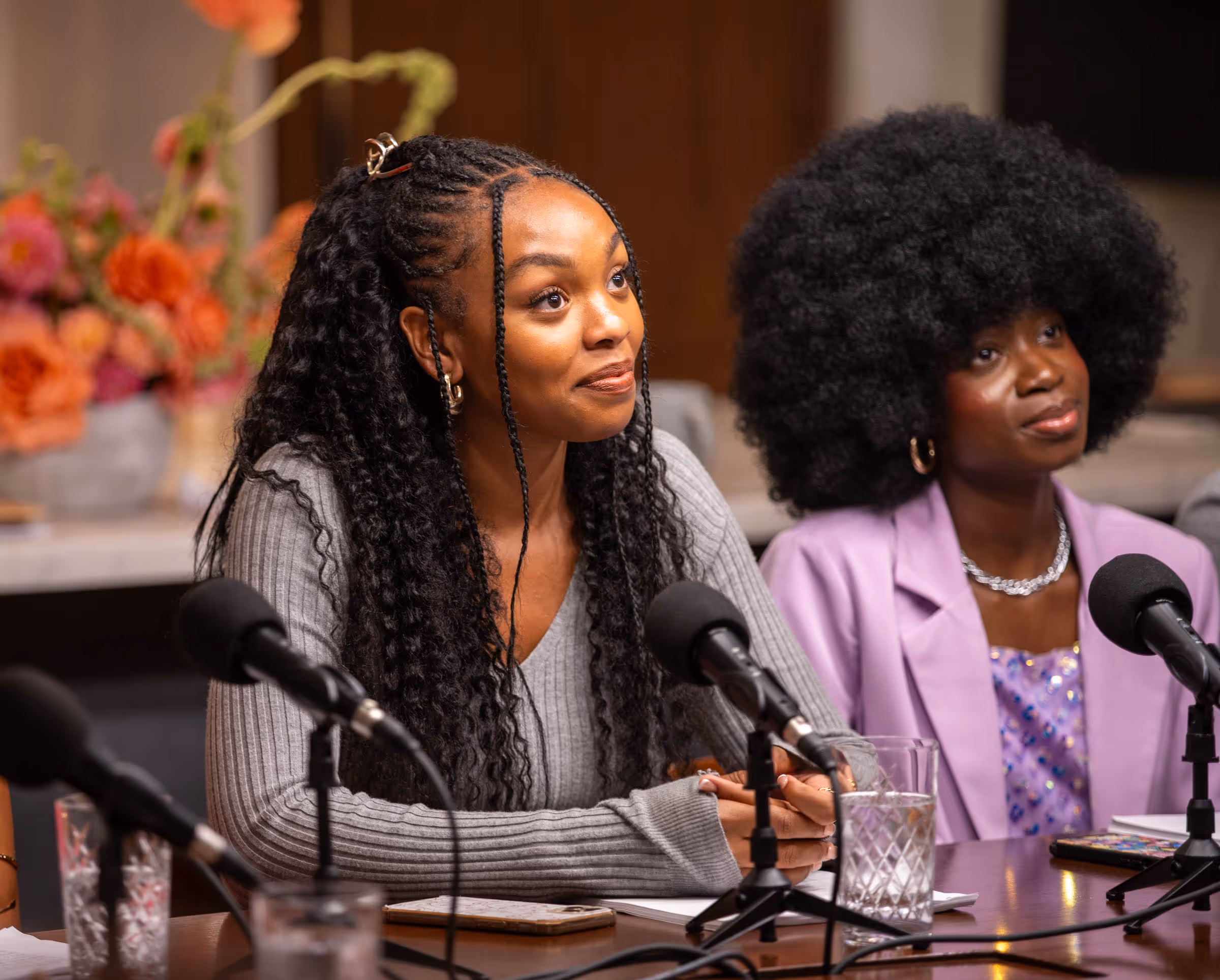 a group of women sitting at a table with microphones
