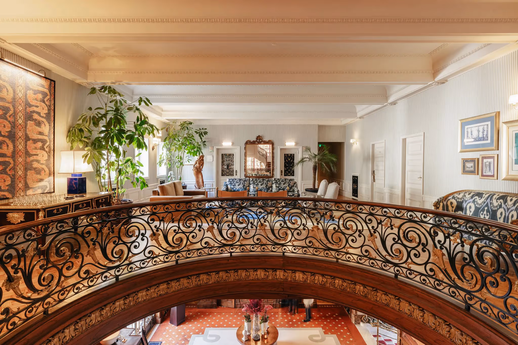 Luxurious lounge at Hotel Experimental Infante Sagres in Porto featuring a golden wrought iron railing and classic furniture.