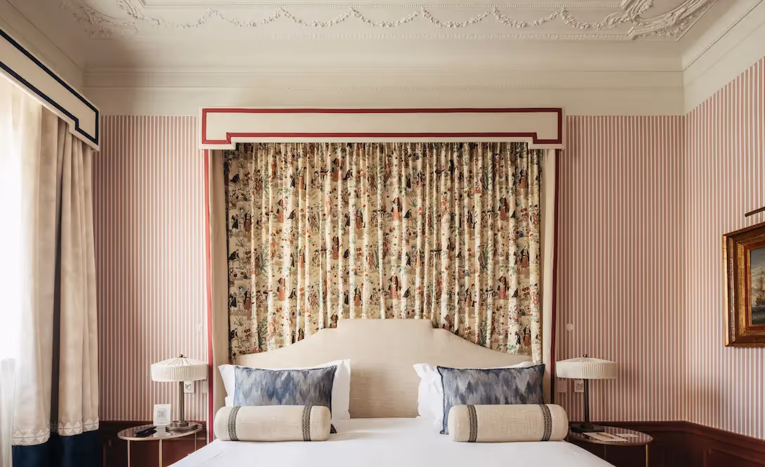 Detail of the headboard and classic patterned tapestry in a suite at Hotel Experimental Infante Sagres in Porto.