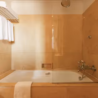 Luxurious marble bathroom with bathtub at Hotel Experimental Infante Sagres in Porto.