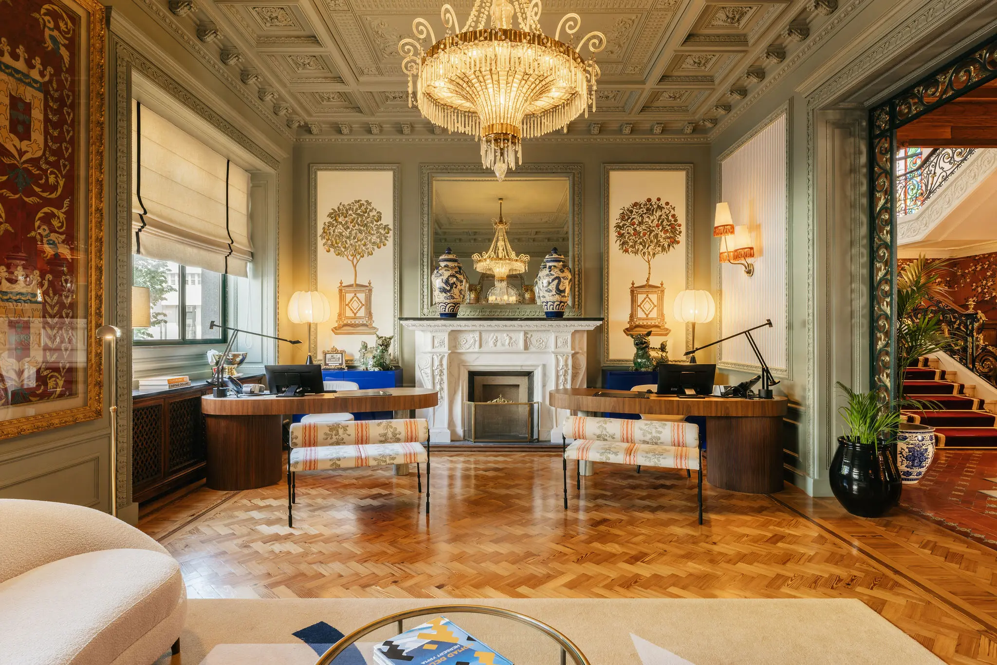 Luxurious reception lounge with a marble fireplace and classical chandelier at the Hotel Experimental Infante Sagres in Porto.