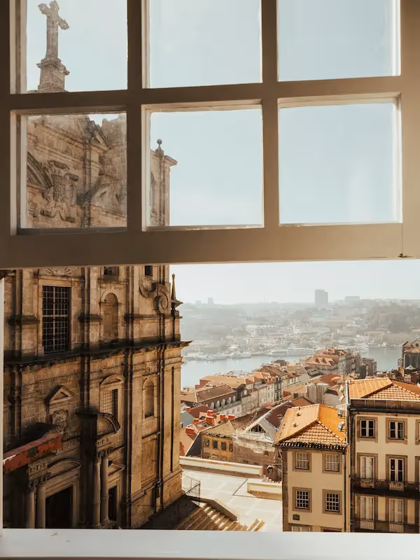 Breathtaking view of baroque church architecture and city rooftops from a window at the Hotel Experimental Infante Sagres in Porto.