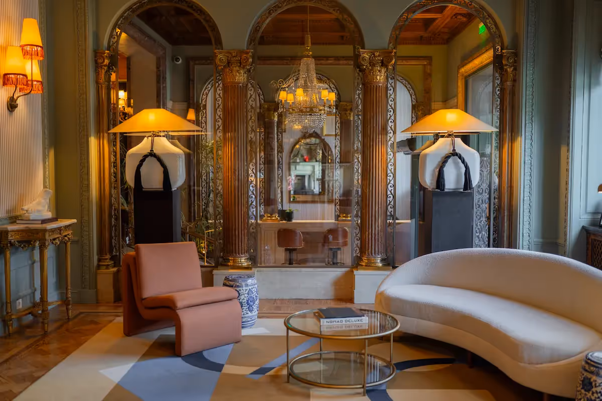 Luxurious lounge with golden columns and modern furniture at Hotel Experimental Infante Sagres in Porto.