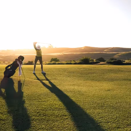 A golfer swinging at sunset during a stay at the Hotel Experimental Infante Sagres in Porto.