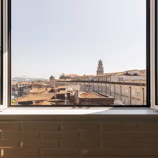 Vista panorámica de los tejados históricos y la Torre de los Clérigos desde el Hotel Experimental Infante Sagres en Oporto.