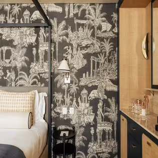 Detail of a headboard with scenic wallpaper depicting ancient scenes at the Hotel Experimental Infante Sagres in Porto.