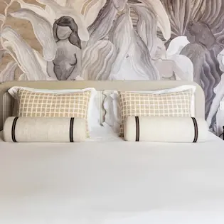 Double bed with figurative wall mural and checkered pillows, Hotel Experimental Infante Sagres in Porto.