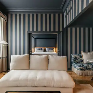 Elegant living room with striped wallpaper at Hotel Experimental Infante Sagres in Porto.