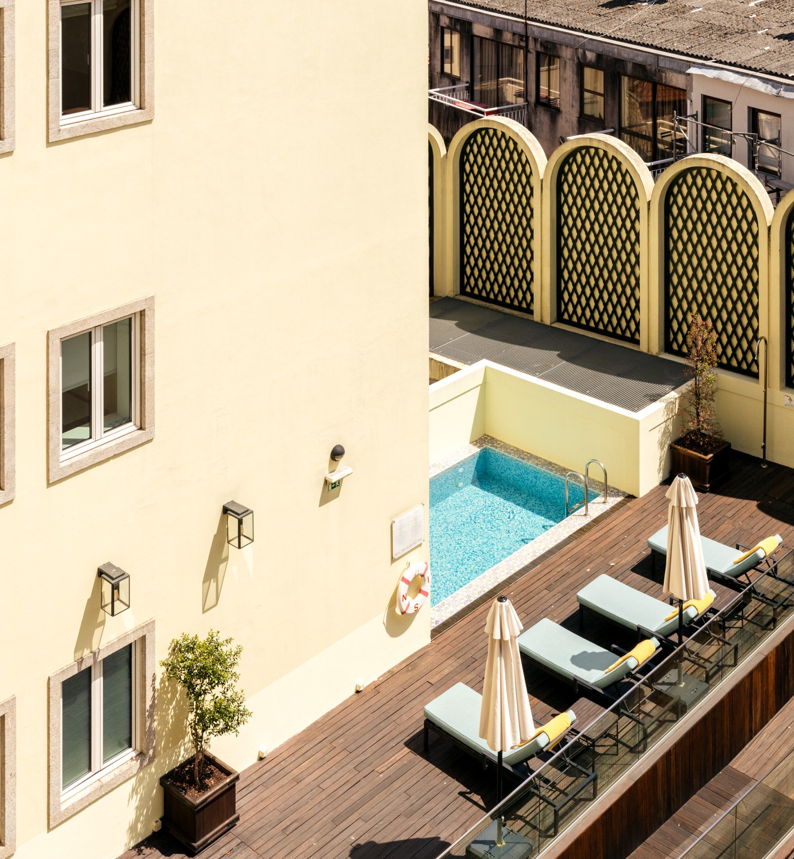 Yellow facade and outdoor patio with pottery at Hotel Experimental Infante Sagres in Porto