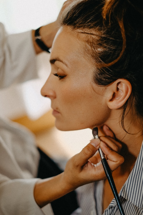 Makeup artist applying makeup to a woman's face.