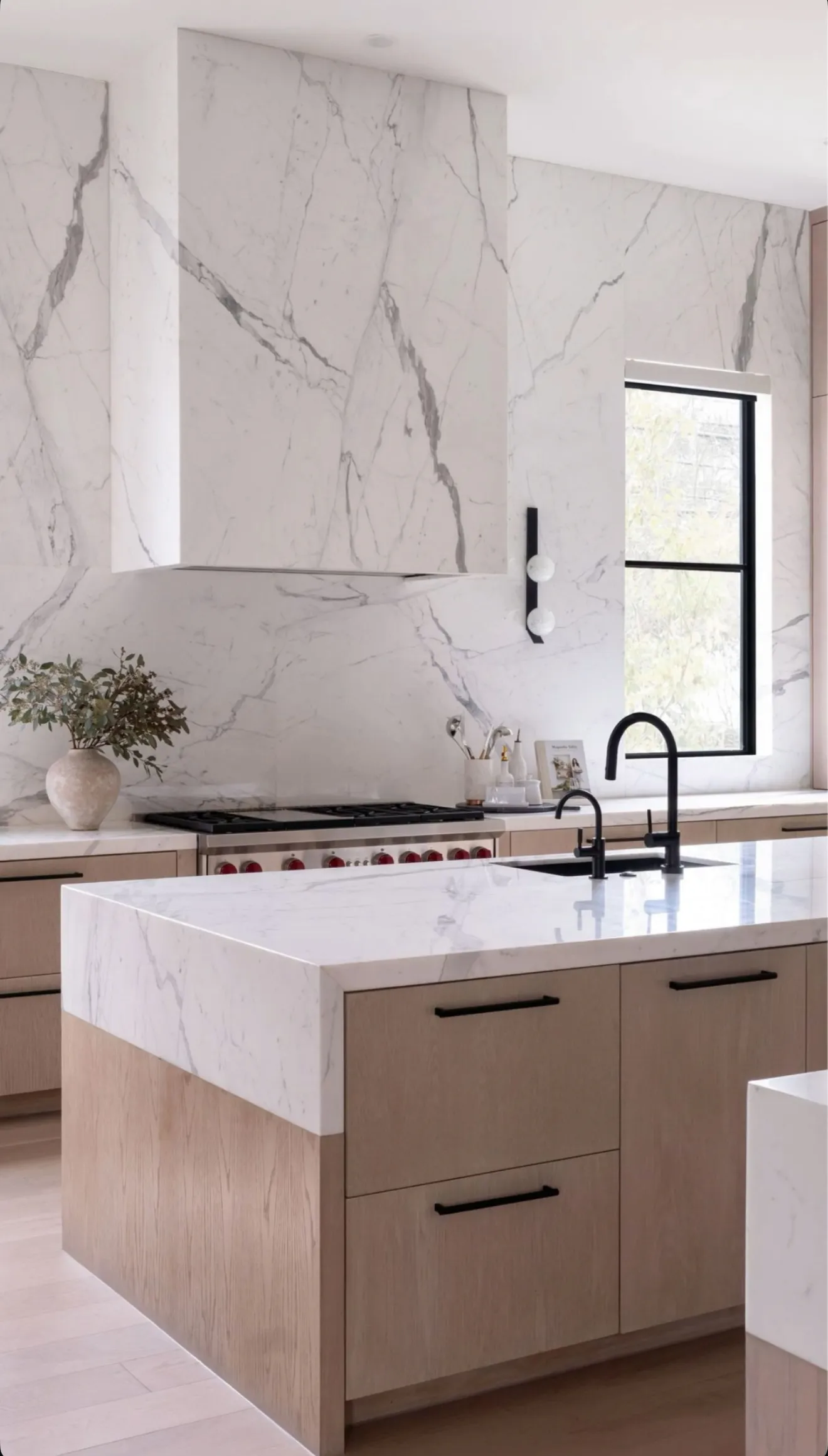 Luxury kitchen remodel featuring marble slab backsplash, waterfall island, and custom cabinetry