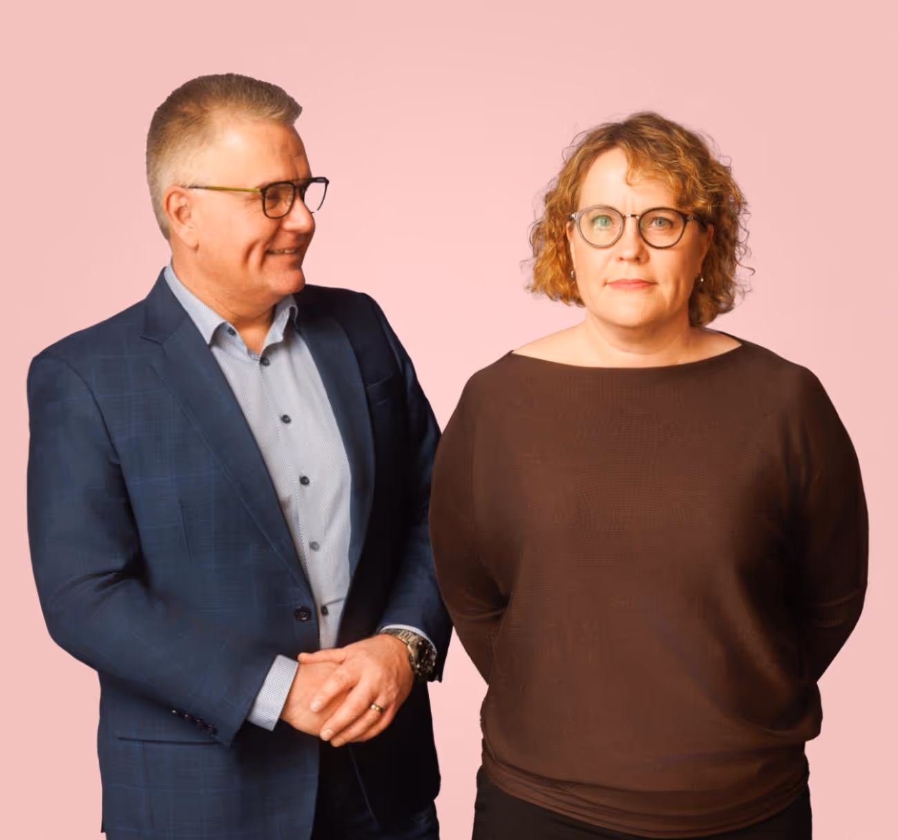 Hemman yrittäjät Jari ja Pia vaaleanpunaisen taustan edessä.