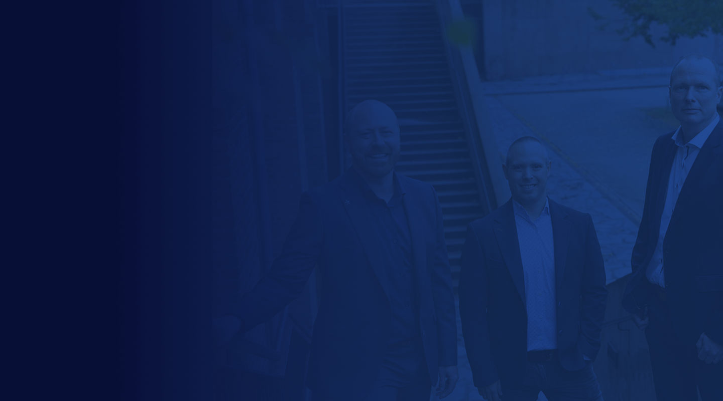 Several people standing together in a dimly lit blue-toned setting