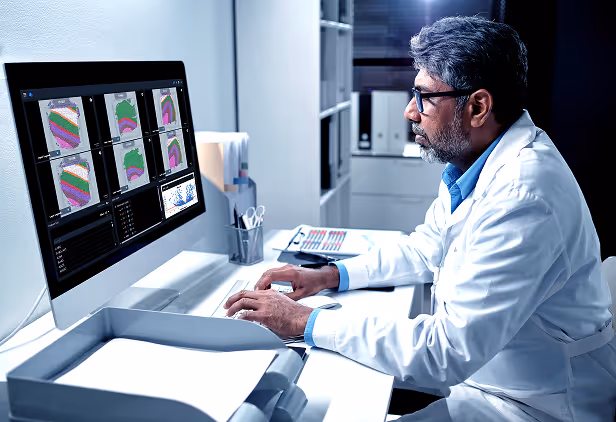 Medical professional analyzing colorful medical imaging scans on computer screen