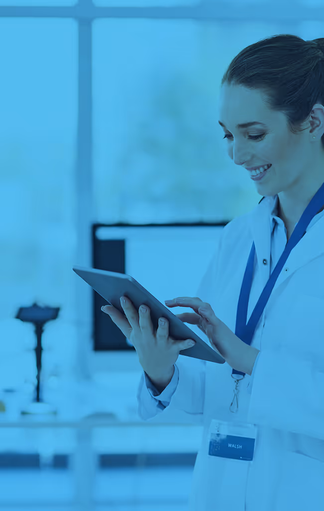 Medical professional using tablet in blue-tinted laboratory setting