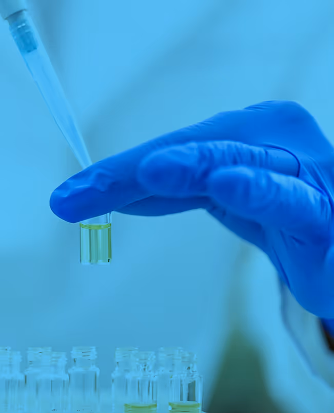 Blue-gloved hand holding test tube in scientific laboratory setting