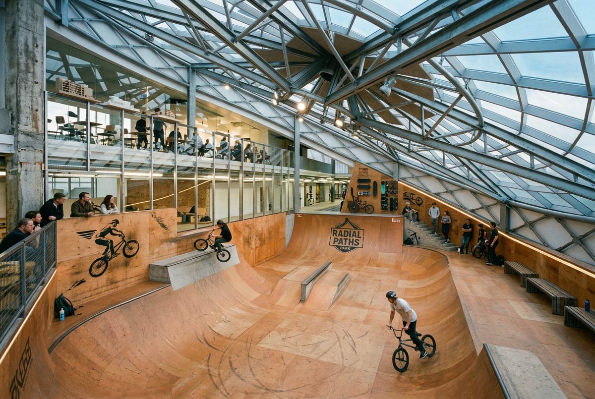 Интериор на BMX парк с рампи, стъклен покрив и тренировъчни зони