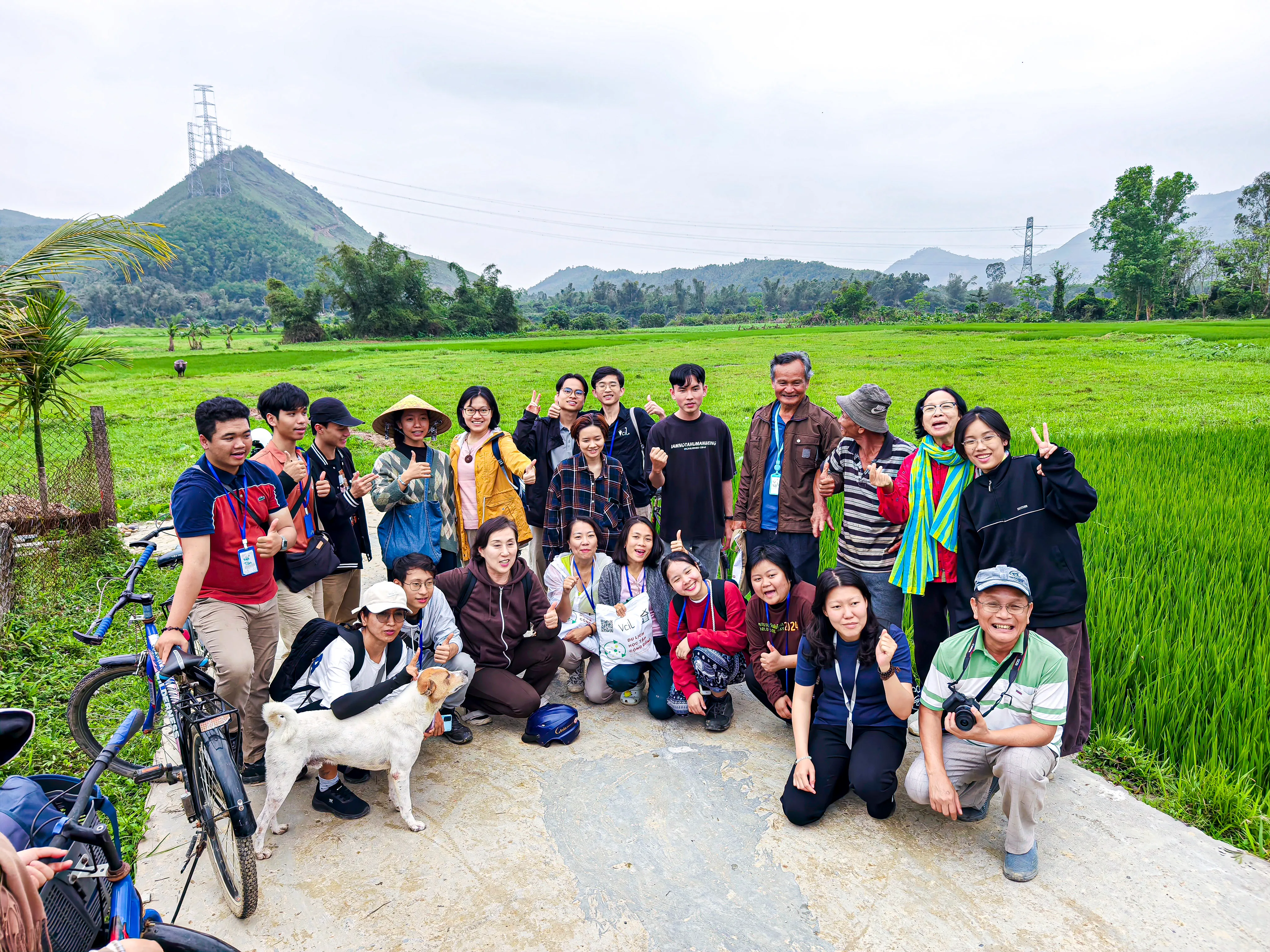 Hai người phụ nữ đội vòng hoa bằng cỏ xanh đang làm việc cùng nhau để thu hoạch cây trồng trên cánh đồng.