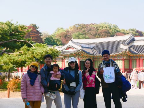 Hai người phụ nữ đội vòng hoa bằng cỏ xanh đang làm việc cùng nhau để thu hoạch cây trồng trên cánh đồng.