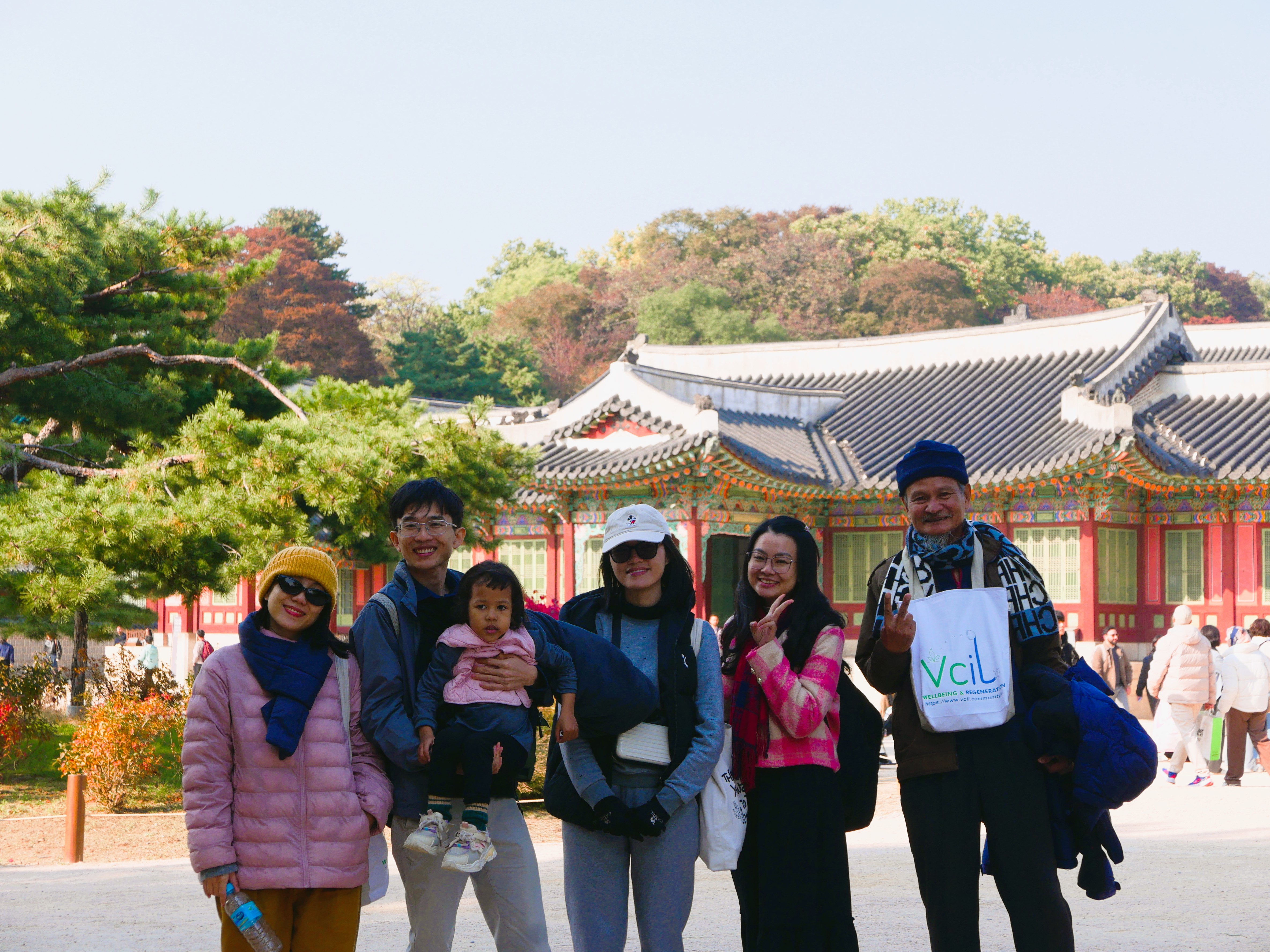 Hai người phụ nữ đội vòng hoa bằng cỏ xanh đang làm việc cùng nhau để thu hoạch cây trồng trên cánh đồng.