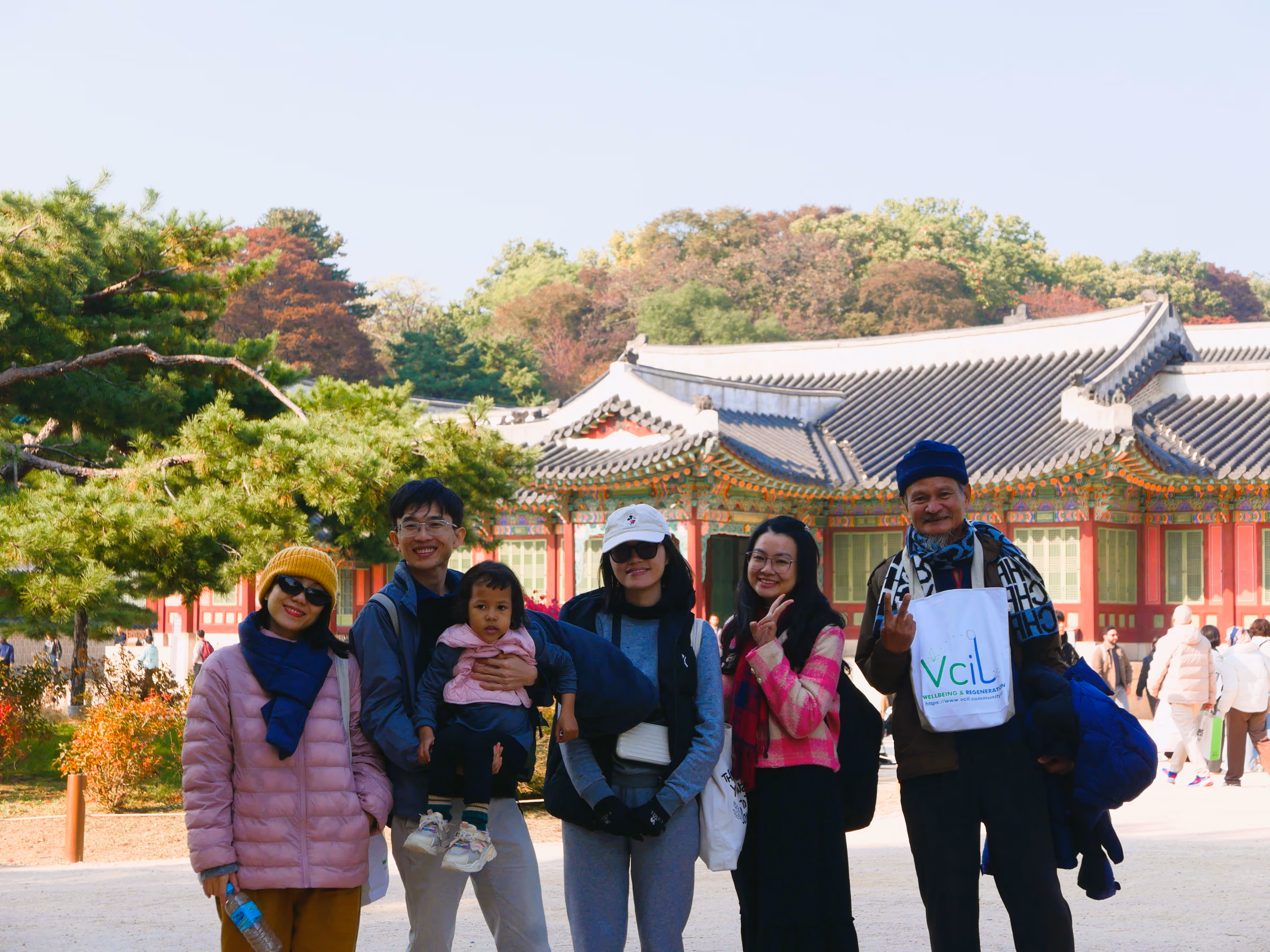 Hai người phụ nữ đội vòng hoa bằng cỏ xanh đang làm việc cùng nhau để thu hoạch cây trồng trên cánh đồng.