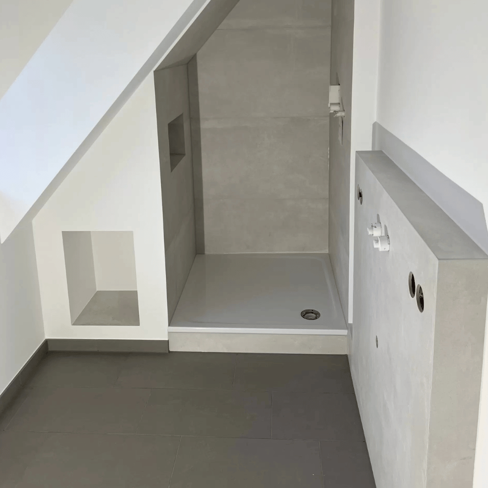 Moderne Dusche mit grauen Wandfliesen im sanierten Badezimmer in Hamburg