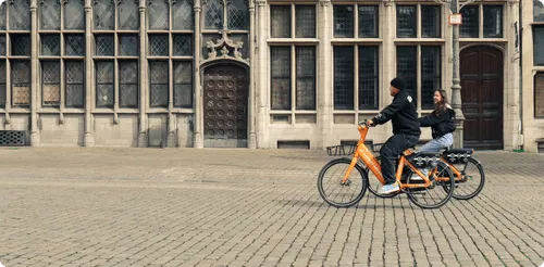 People on bikes near a building