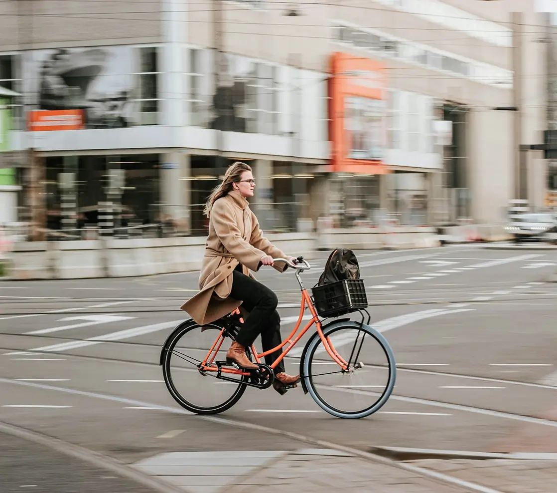 A woman riding a bike down a city street.