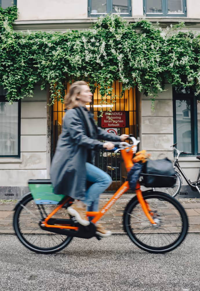 A woman riding a bike down a street.
