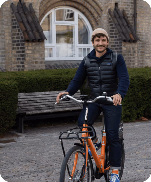 A man riding a bike in front of a building.