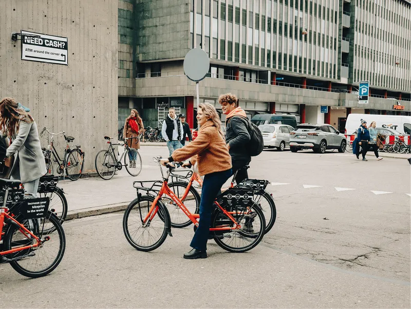 A group of people riding bikes down a street.