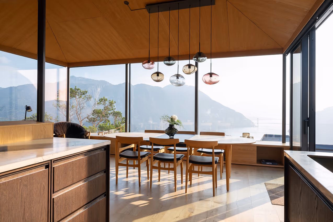 Interiørfoto fra The Bolder med spiseplass, store vinduer og utsikt mot Lysefjorden