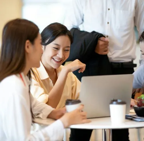 Gruppe von Kollegen, die an einem Tisch sitzen.